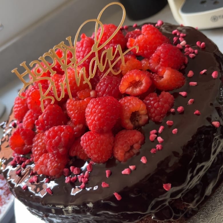 Chocolate birthday cake topped with fresh raspberries